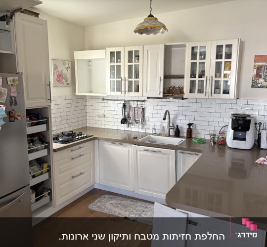 מטבח מעוצב בצבע לבן עם ארון מזווה בעל מגירות נשלפות ומשטח עבודה